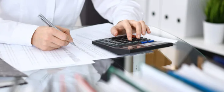 Female bookkeeper or financial inspector making report, calculating or checking balance. Internal Revenue Service checking financial document. Audit concept in business.